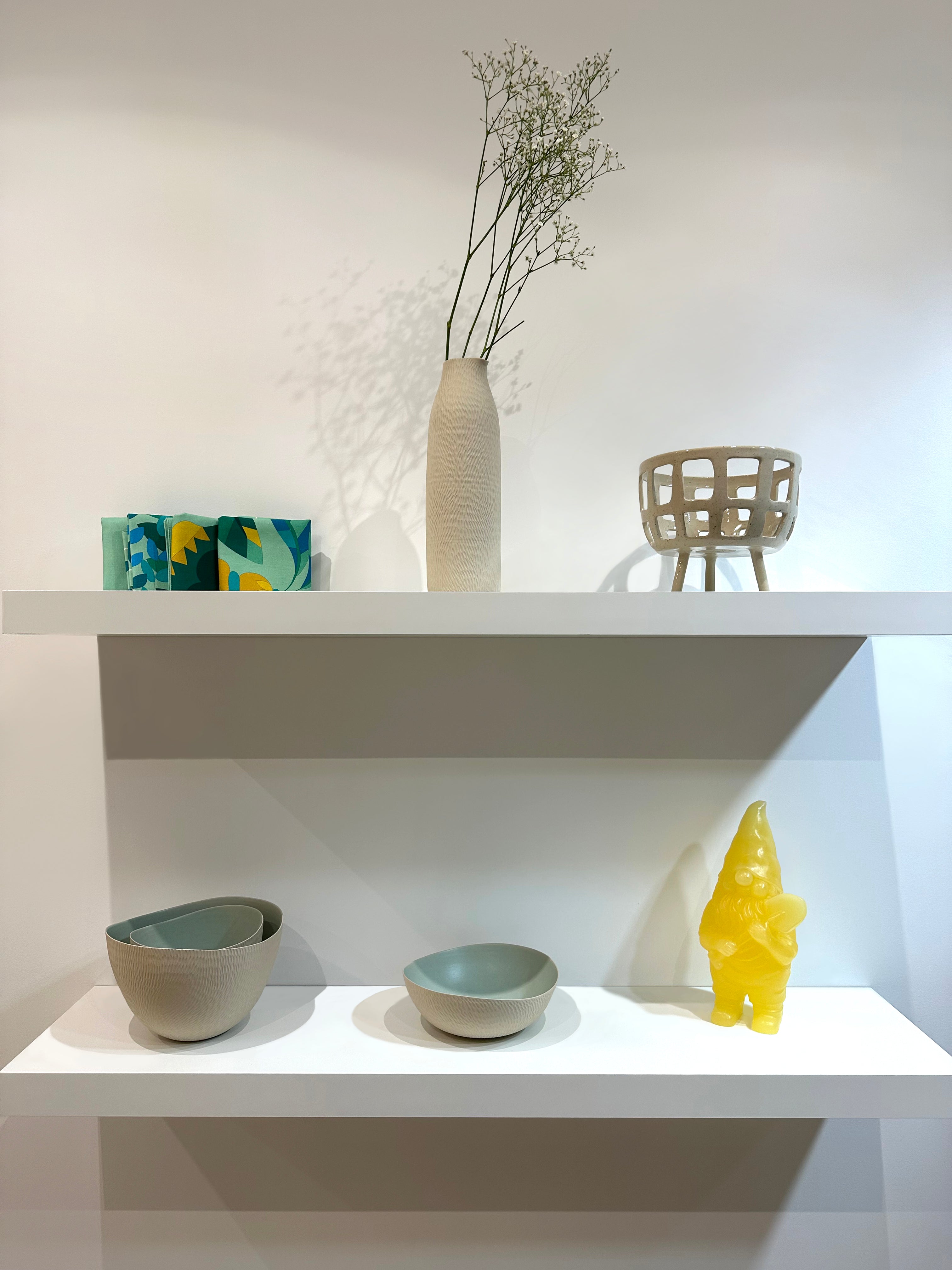 Photo intérieur boutique céramique emmanuelle manche ,panier à fruit Fougasse céramique, nain en cire jaune et sets de table Alto Duo Design